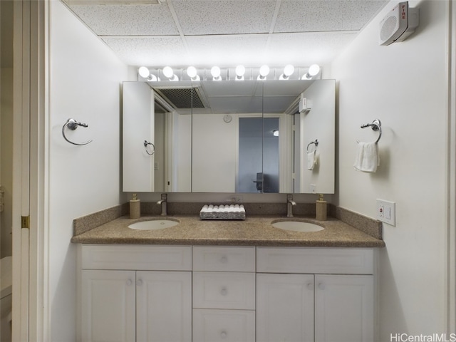 bathroom featuring vanity and a drop ceiling