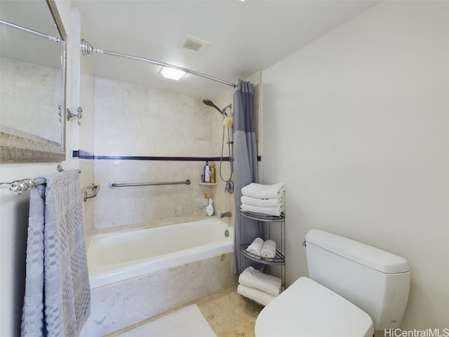 bathroom featuring shower / tub combo and toilet