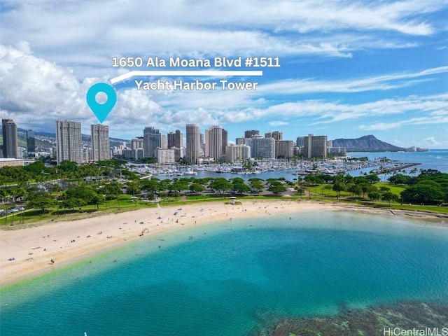 birds eye view of property with a water view and a beach view