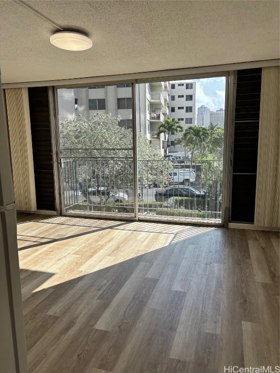 entryway with floor to ceiling windows, hardwood / wood-style floors, and a textured ceiling