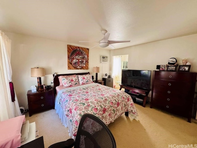 bedroom with ceiling fan, light colored carpet, and a textured ceiling