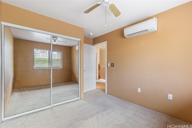 unfurnished bedroom featuring a wall mounted air conditioner, ceiling fan, light carpet, and a closet