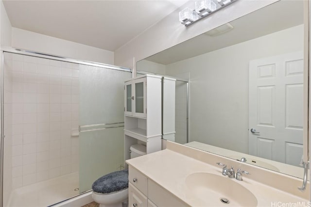 bathroom featuring vanity, toilet, and a shower with door