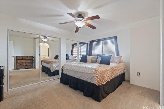 carpeted bedroom featuring two closets and ceiling fan