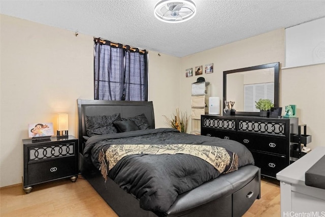 bedroom with light hardwood / wood-style flooring and a textured ceiling