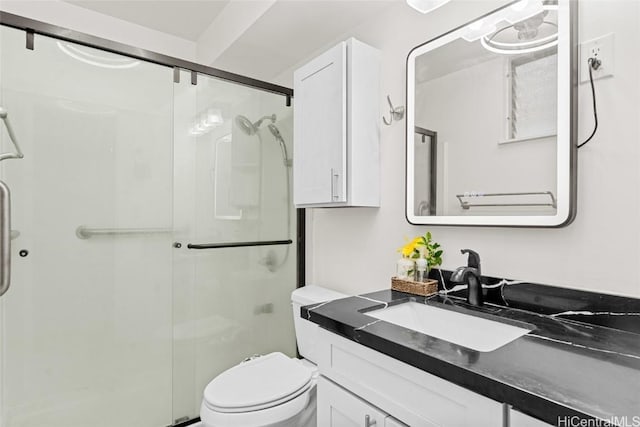 bathroom featuring vanity, toilet, and an enclosed shower