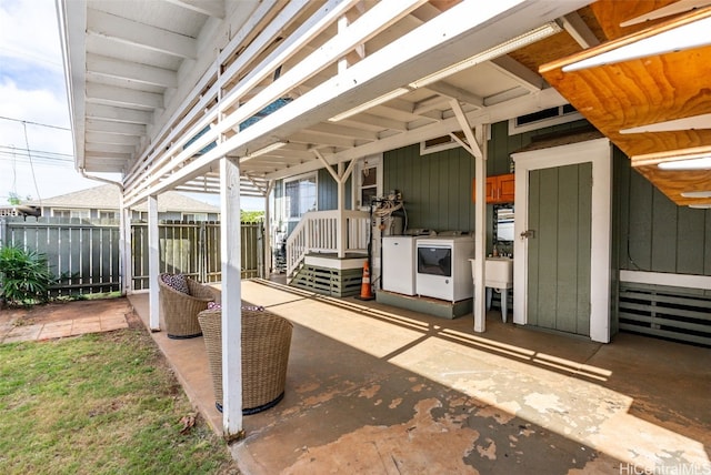 view of patio / terrace featuring washing machine and clothes dryer and sink