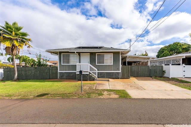 bungalow-style home with a front yard and solar panels