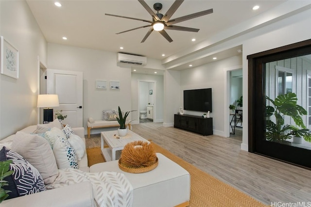 living room featuring an AC wall unit and light hardwood / wood-style flooring