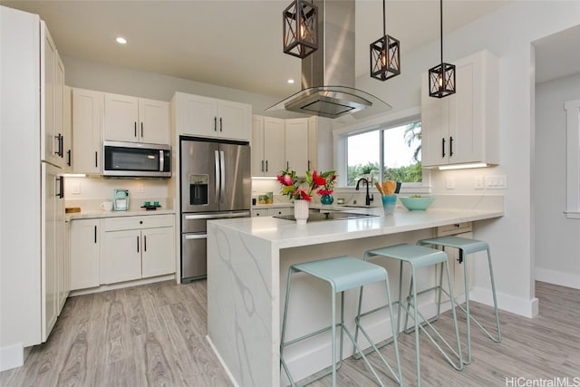 kitchen with stainless steel appliances, island range hood, and white cabinetry