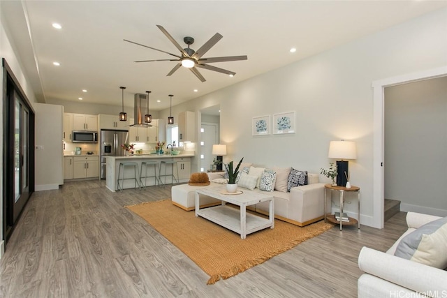 living room with ceiling fan and light wood-type flooring