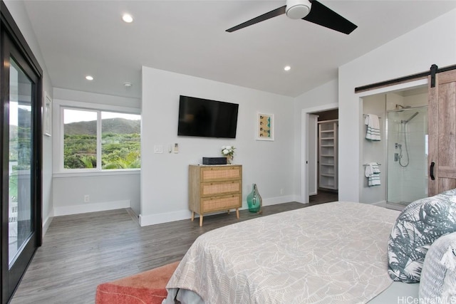 bedroom with ceiling fan, a barn door, access to exterior, lofted ceiling, and a spacious closet