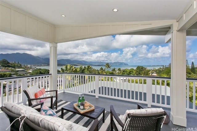 balcony featuring a water and mountain view and outdoor lounge area