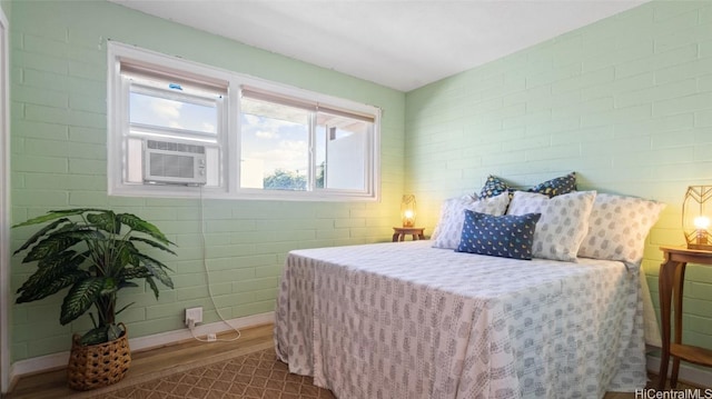 bedroom featuring cooling unit and brick wall