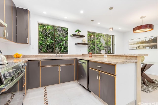 kitchen featuring kitchen peninsula, stainless steel appliances, light stone counters, and decorative light fixtures