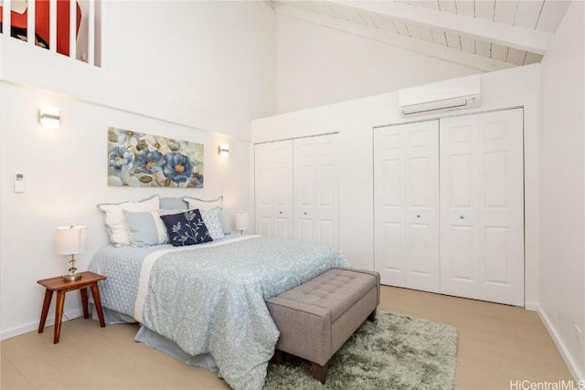 bedroom featuring a wall mounted AC, high vaulted ceiling, beamed ceiling, and multiple closets