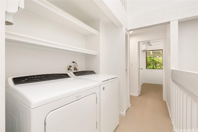 washroom with light hardwood / wood-style floors and washer and clothes dryer