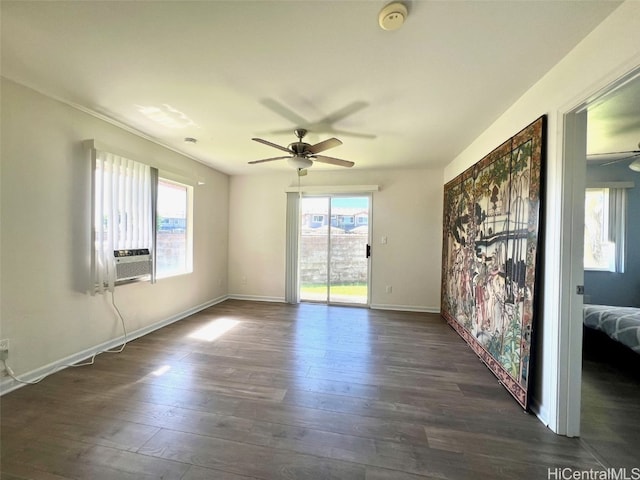 empty room featuring cooling unit, ceiling fan, plenty of natural light, and dark wood-type flooring