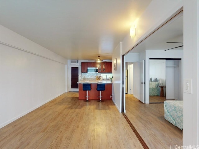 kitchen featuring decorative backsplash, a breakfast bar, and light wood-type flooring