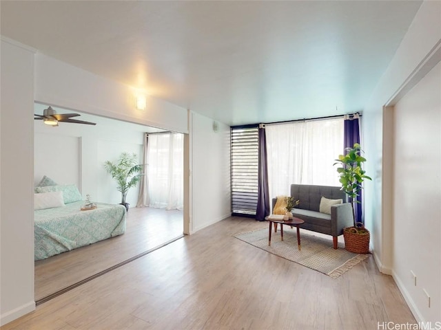 living room with light hardwood / wood-style flooring and ceiling fan