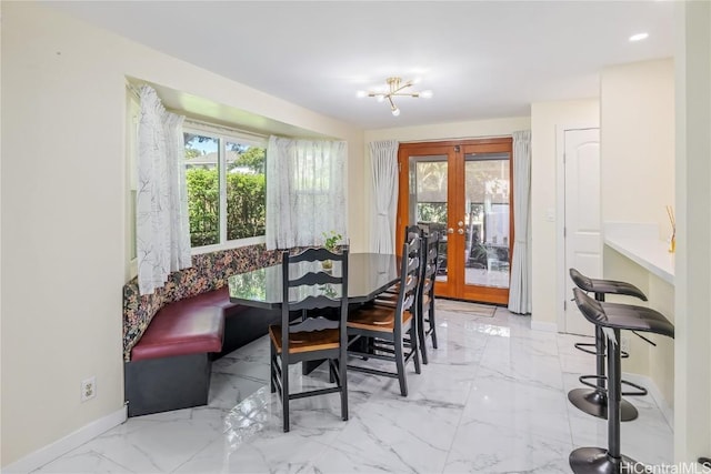 dining space featuring french doors and an inviting chandelier