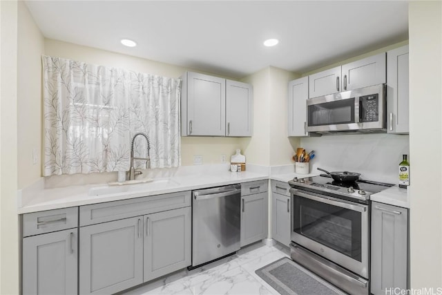 kitchen with appliances with stainless steel finishes, sink, and gray cabinets