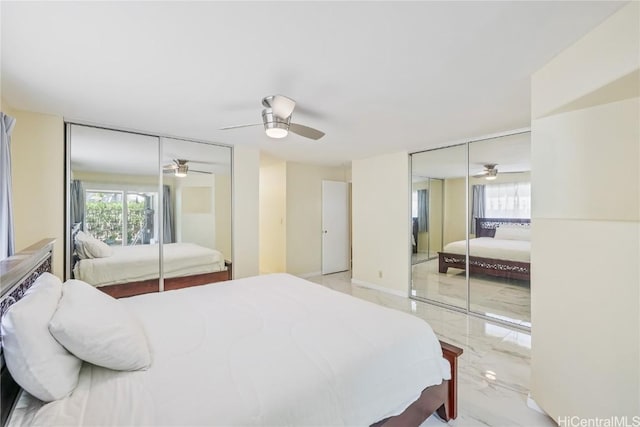 bedroom with ceiling fan and two closets