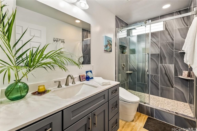 bathroom with vanity, an enclosed shower, and toilet