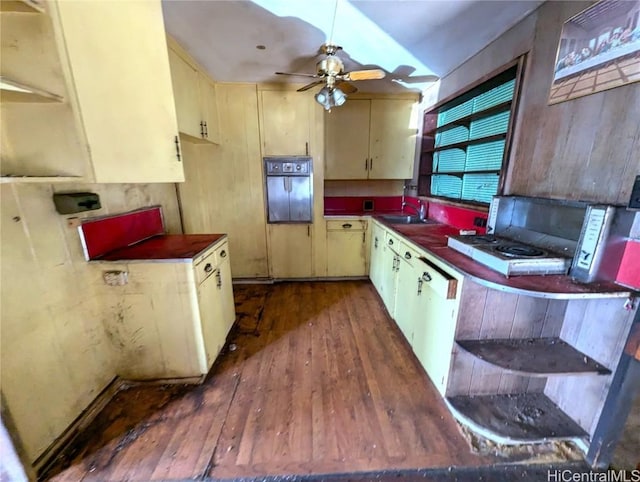 kitchen featuring ceiling fan, sink, dark hardwood / wood-style flooring, cream cabinets, and black oven