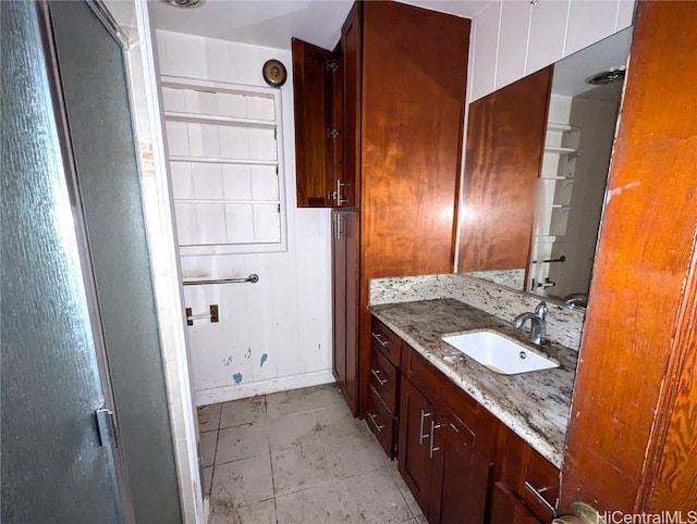 bathroom featuring a shower with door and vanity