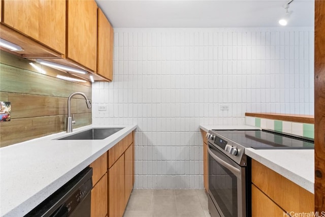 kitchen featuring electric stove, sink, light tile patterned floors, tile walls, and black dishwasher