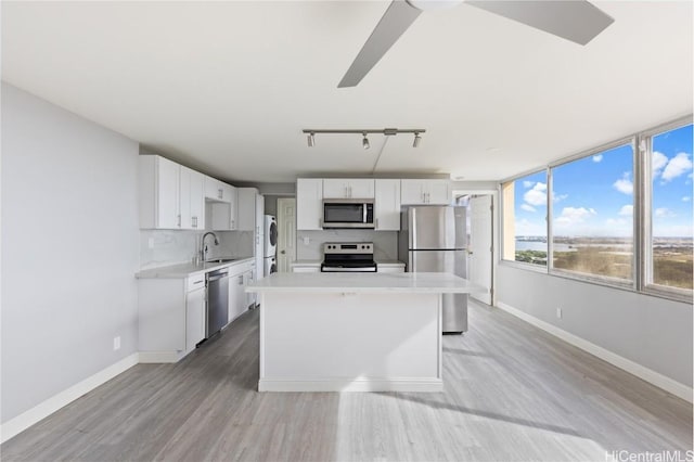 kitchen featuring white cabinetry, appliances with stainless steel finishes, sink, and a kitchen island