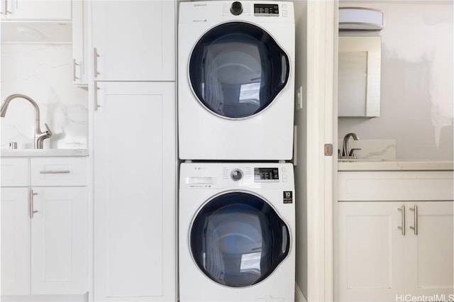 laundry room with stacked washer / dryer and sink