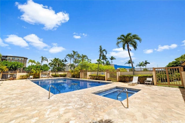 view of swimming pool with a hot tub and a patio