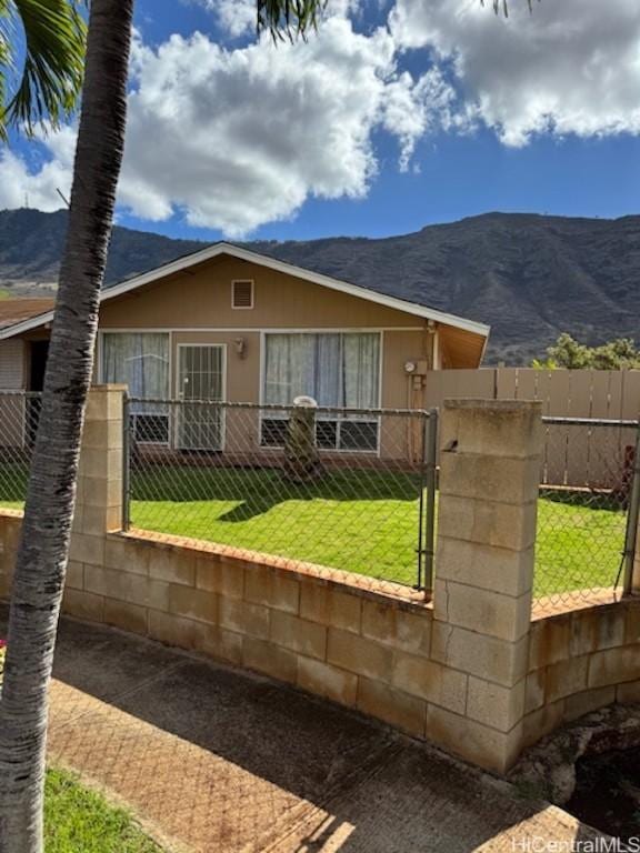 view of front of house with a mountain view and a front lawn