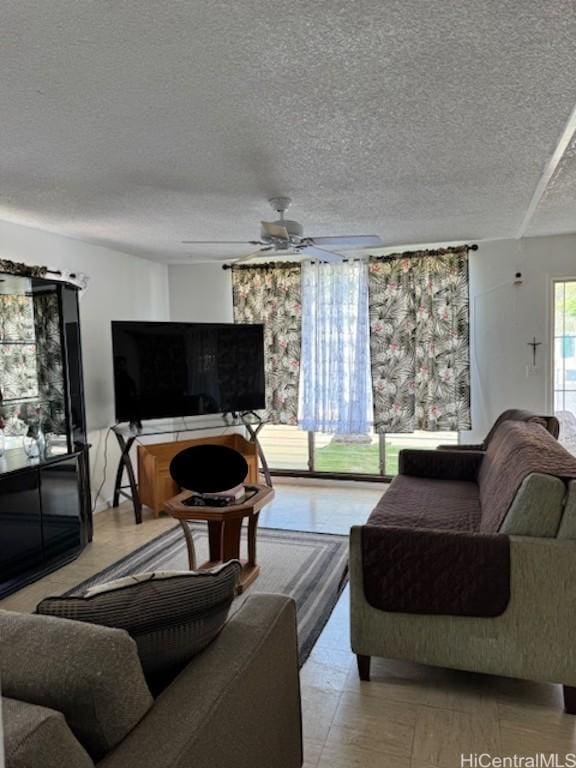 living room with ceiling fan and a textured ceiling