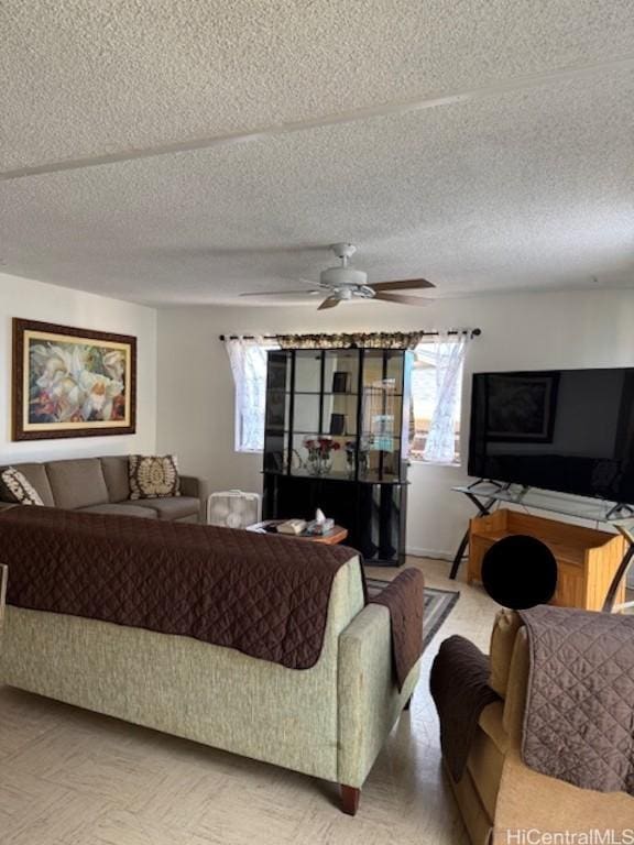 living room with a textured ceiling and ceiling fan