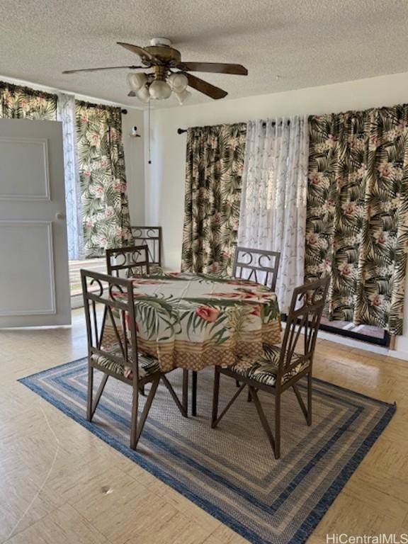 dining space with ceiling fan and a textured ceiling