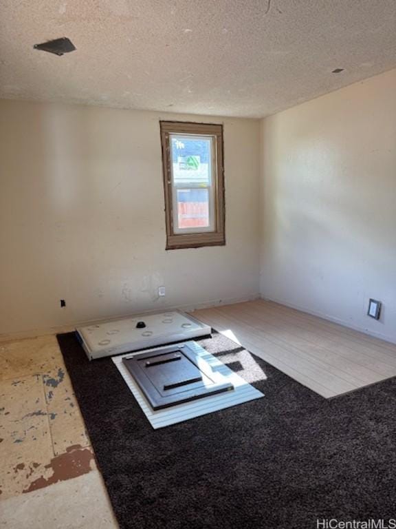 unfurnished room with a textured ceiling