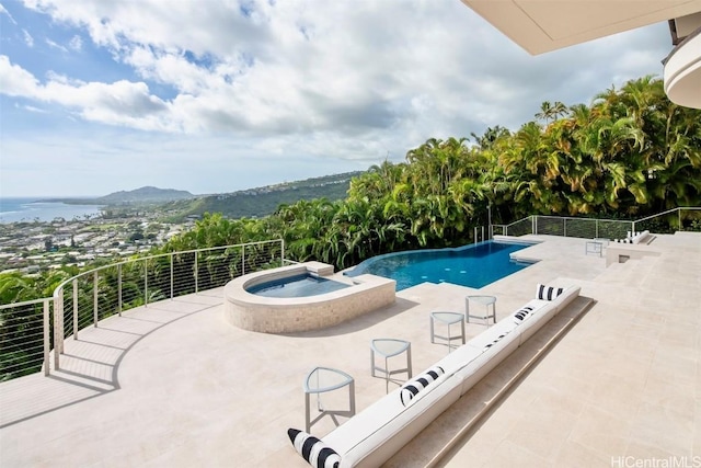 view of swimming pool featuring an in ground hot tub, a patio, and a water and mountain view