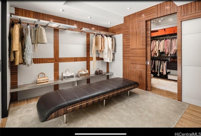 mudroom featuring light hardwood / wood-style flooring and wooden walls