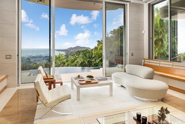 sunroom featuring a water view