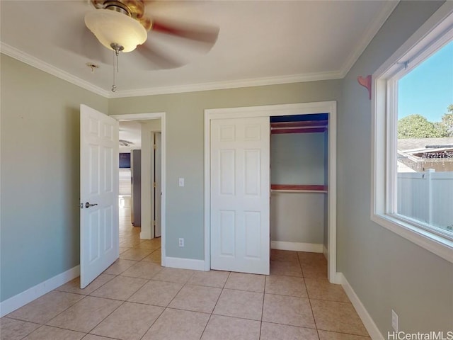 unfurnished bedroom with ceiling fan, ornamental molding, light tile patterned floors, and a closet