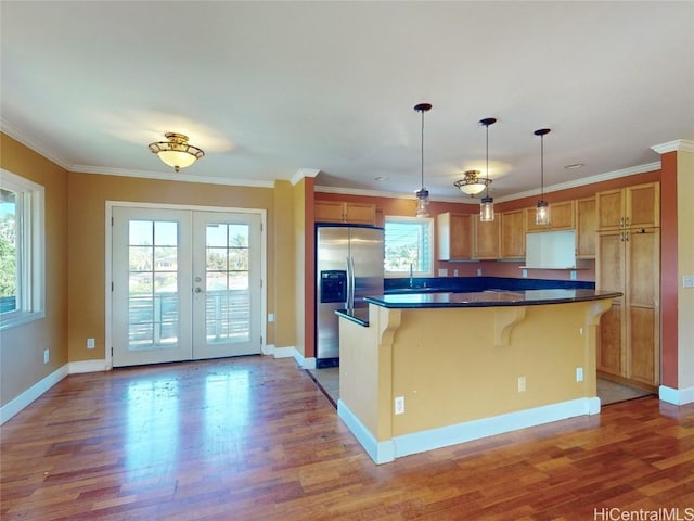 kitchen featuring a center island, french doors, stainless steel fridge with ice dispenser, crown molding, and decorative light fixtures