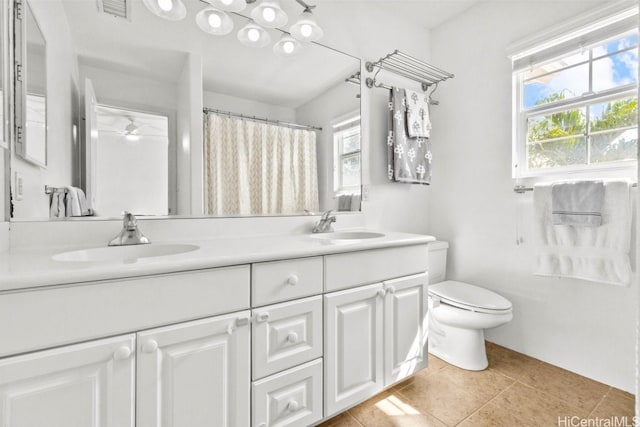 bathroom featuring tile patterned flooring, vanity, toilet, and ceiling fan