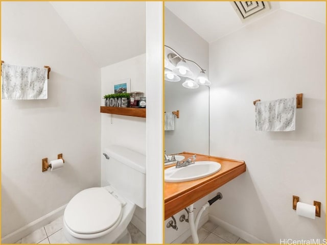 bathroom featuring tile patterned flooring, sink, vaulted ceiling, and toilet