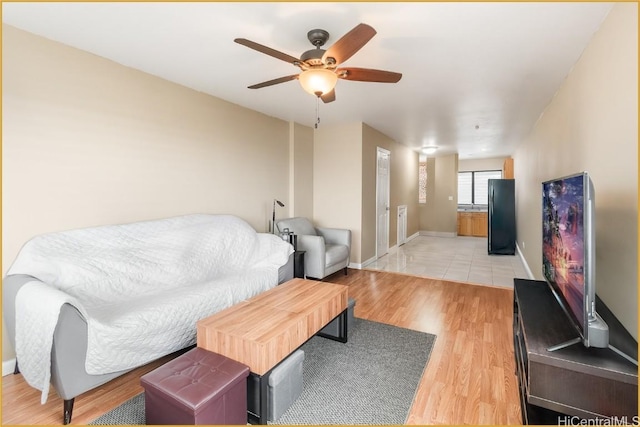 living room with light wood-type flooring and ceiling fan