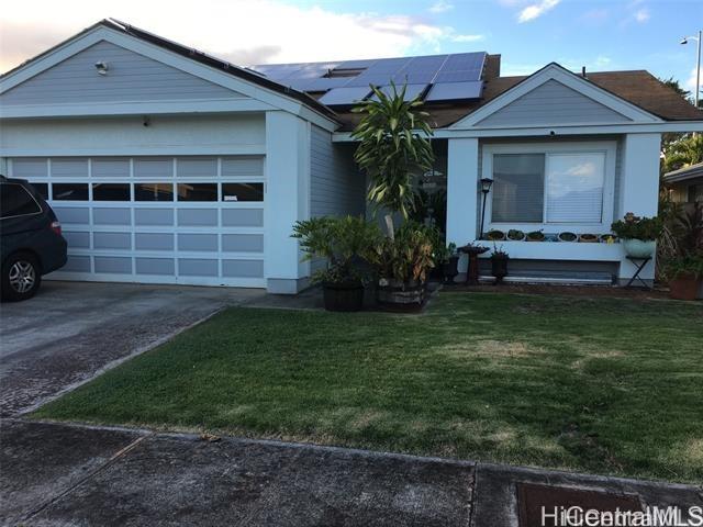 view of front of home with a front lawn and solar panels