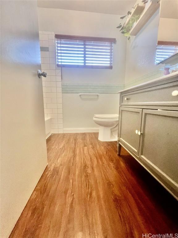 bathroom featuring hardwood / wood-style floors, tub / shower combination, and toilet