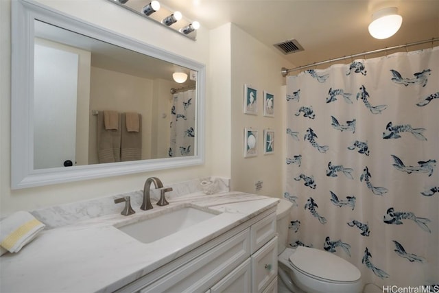 bathroom featuring curtained shower, vanity, and toilet